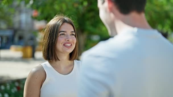 Belo casal sorrindo confiante de pé juntos falando no parque - Filmagem, Vídeo