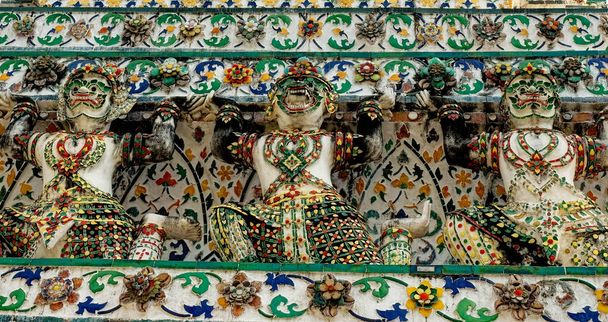 Kolme koristeellista patsasta temppelin seinällä. Patsaissa on kolme hahmoa, joista jokaisella on erilainen asento.. - Valokuva, kuva