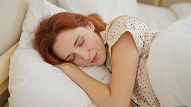 Молодая рыжая женщина напряжена лежа на кровати в спальне - Кадры, видео