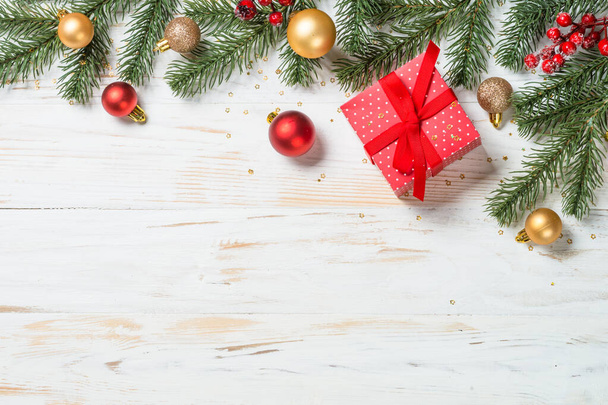 赤いリボンと休日の装飾が施されたクリスマスプレゼントボックス。白木のテーブルの上からの眺め. - 写真・画像