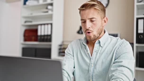 Giovane uomo caucasico operaio aziendale utilizzando laptop di lavoro stressato in ufficio - Filmati, video