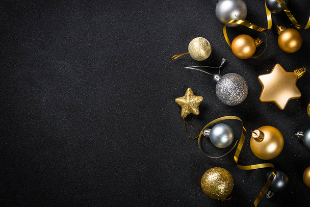 Schwarzer weihnachtlicher Hintergrund mit goldenen Dekorationen. Flaches Laienbild mit Raum für Gestaltung. - Foto, Bild