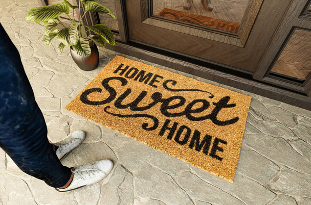 Home Sweet Home Fußmatte und Schuhe eines Mannes, der auf der Veranda vor der Haustür steht. - Foto, Bild