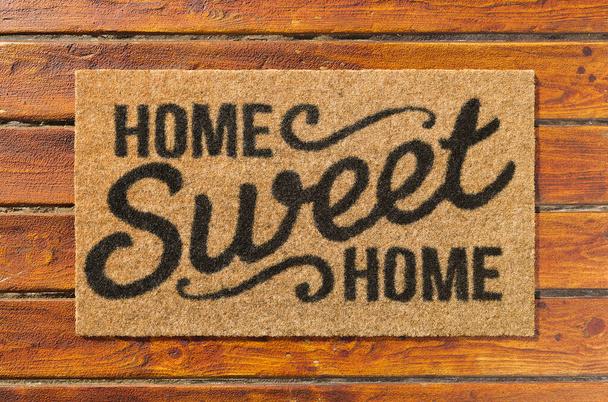 Overhead of Home Sweet Home doormat on the wood plank porch. - Photo, Image