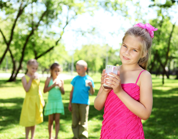 Girl drinking milk in the summer park - Φωτογραφία, εικόνα
