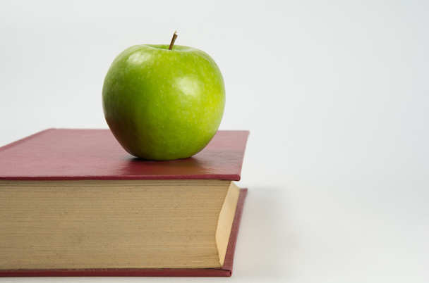 Groene appel op een boek - Foto, afbeelding