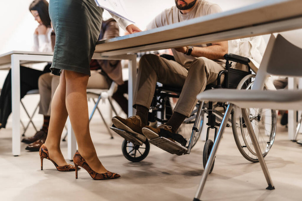 Бизнесмен в инвалидной коляске присутствовал на встрече в конференц-зале - Фото, изображение