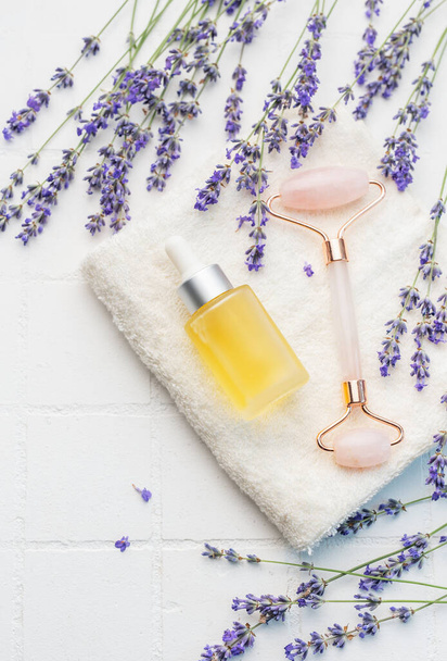 Lavendelbad. Lavendel natürliches ätherisches Öl und frischer Lavendel auf weißem Fliesenhintergrund. - Foto, Bild