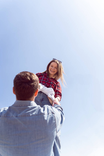 Девушка улыбается, глядя на своего парня, который держит ее в воздухе - Фото, изображение