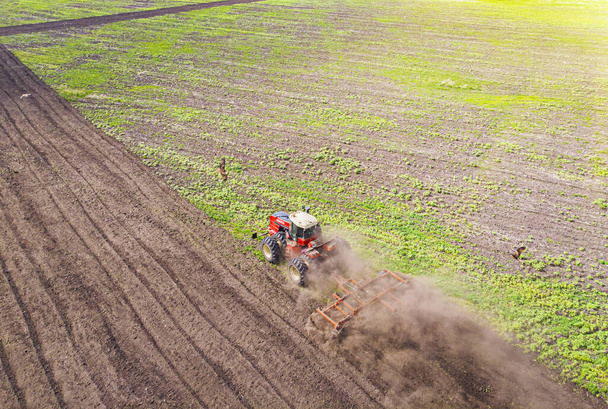 Aerial view of agricultural tractor doing stubble field fall tillage on farmland, top view from drone pov - Photo, Image