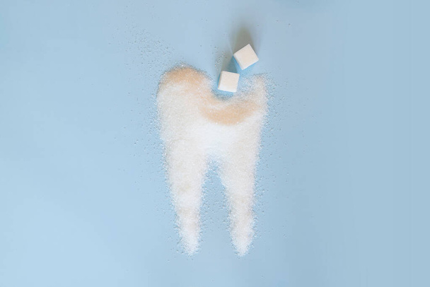 Dente molare fatto di zucchero su sfondo blu. Concetto denti sani - Foto, immagini