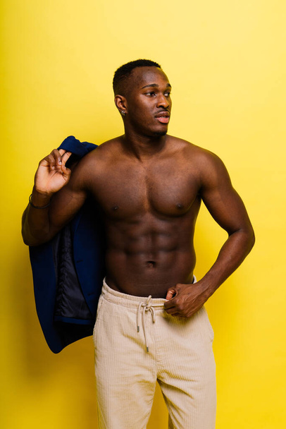 A handsome and muscular young man posing in a studio. - Fotó, kép
