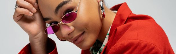 portré boldog afro-amerikai modell stílusos öltözékben és napszemüveg szürke háttér, banner - Fotó, kép