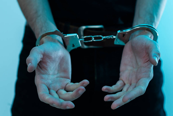 Чоловічі руки в наручниках чорний фон. Високоякісна фотографія
 - Фото, зображення
