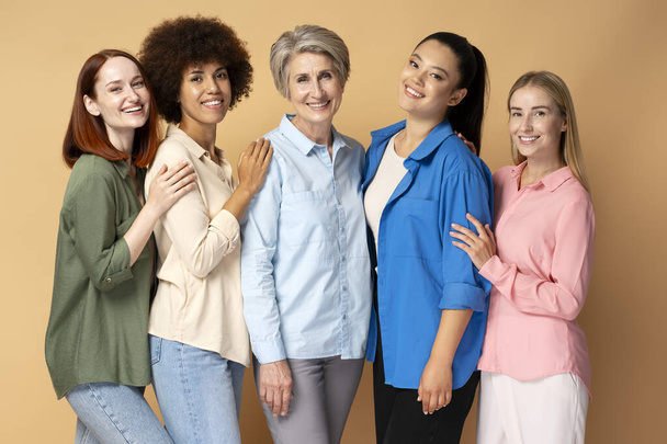 Grupo de mulheres multirraciais sorridentes vestindo camisas elegantes olhando para a câmera isolada no fundo - Foto, Imagem