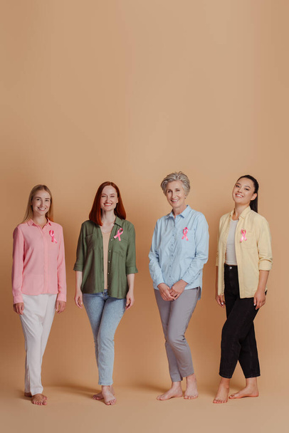 Gruppe von Frauen mit rosa Schleife isoliert auf dem Hintergrund. Gesundheitsversorgung. Brustkrebs-Bewusstsein - Foto, Bild