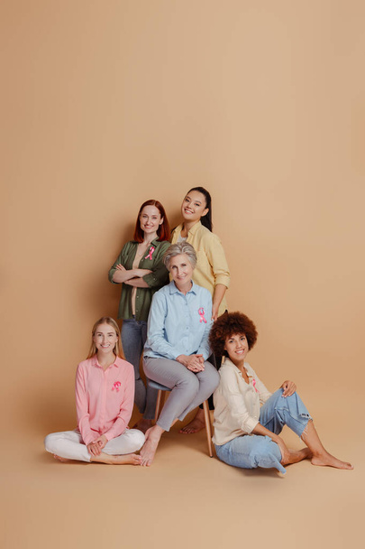 Ryhmä naisia yllään vaaleanpunainen nauha eristetty taustalla. Terveydenhuolto. Rintasyöpätietoisuus - Valokuva, kuva