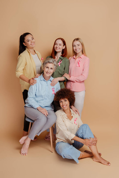 バックグラウンドで隔離されたピンクのリボンを着用する女性のグループ. ヘルスケア。 乳がんに対する意識 - 写真・画像