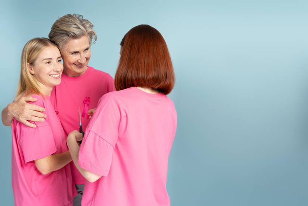 Lächelnde multiethnische Frauen in T-Shirts mit rosa Schleife vereinzelt. Brustkrebs-Aufklärungsmonat - Foto, Bild