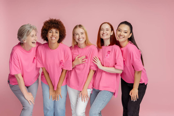 Groep vrouwen met roze lint communicatie geïsoleerd op roze achtergrond. Bewustwording van borstkanker - Foto, afbeelding