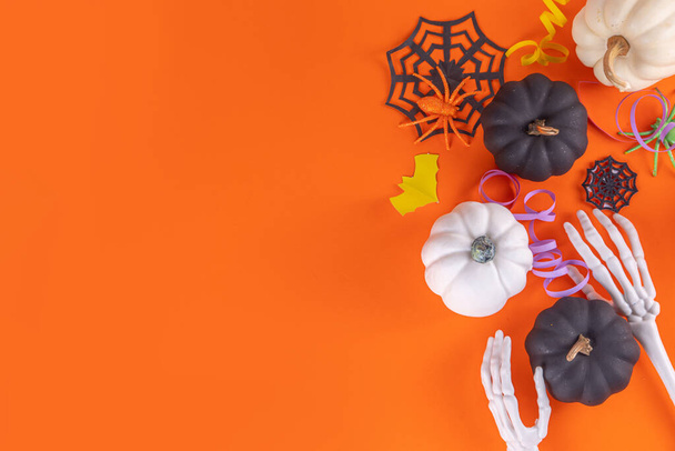 Halloween hoog gekleurde gele achtergrond met kleurrijke feestdagen accessoires en decor, spinnen, spinnenwebben, pompoenen, vleermuizen, spoken, bovenaanzicht platte lay kopieerruimte - Foto, afbeelding