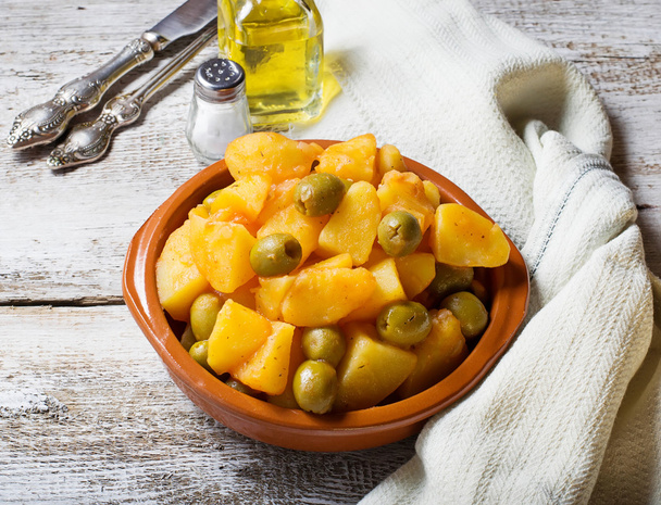 Haudutettuja perunoita oliivien ja tomaattikastikkeen kanssa
 - Valokuva, kuva