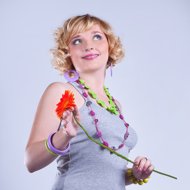 Beautiful young blond curly woman with a flower - Foto, imagen