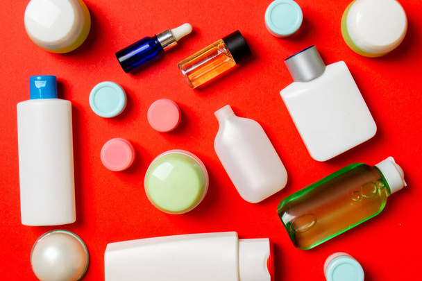 Draufsicht auf verschiedene Kosmetikflaschen und Kosmetikbehälter auf farbigem Hintergrund. Flache Lagekomposition mit Kopierraum. - Foto, Bild