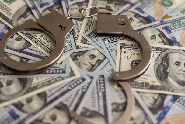 σιδερένιες χειροπέδες για την κράτηση εγκληματιών στο παρασκήνιο των δολαρίων μας. διαφθορά. Υψηλής ποιότητας φωτογραφία - Φωτογραφία, εικόνα