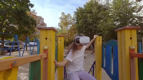 Niña juega un juego en un casco de realidad virtual. Ella va a los deportes en gafas de realidad virtual. - Imágenes, Vídeo