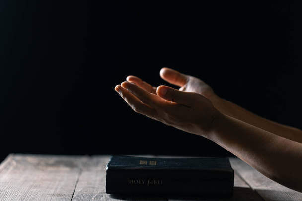Christliches Gebet zur Lebenskrise zu Gott. Frau betet um Gottes Segen, um sich ein besseres Leben zu wünschen. Frauenhände, die mit der Bibel zu Gott beten. Bittet um Vergebung und glaubt an das Gute. - Foto, Bild