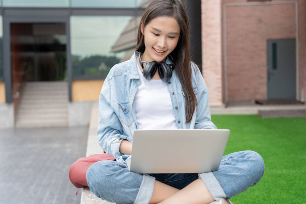 Beautiful Asian woman female student excited checking language test results on laptop. Smile girl happy study online. book in college campus. Portrait female on international Asia University. Education, study, school - Foto, immagini
