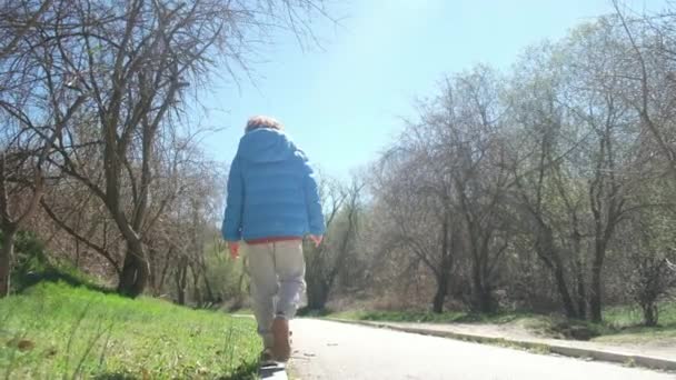 O menino caminha ao longo do passeio e mantém o equilíbrio - Filmagem, Vídeo