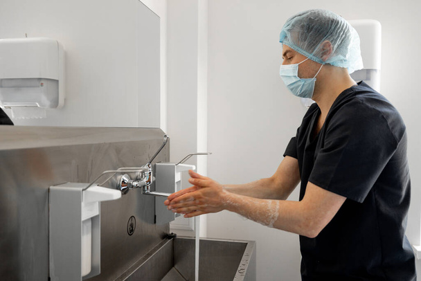 A sebész óvatosan mos kezet a műtétre készülve. A sterilitás és a műtét fogalma - Fotó, kép