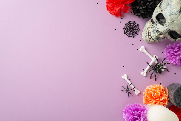 Mexická kultura září na této fotce shora. Děsivá lebka zdobená květinami, konfety a kostmi, zasazená do pastelově fialového pozadí obohaceného o strašidelné detaily a reklamní nebo uvítací textový prostor - Fotografie, Obrázek