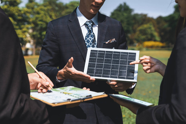 Zewnętrzne spotkanie biznesowe na temat energii słonecznej, grupy biznesmenów pracujących i burzy mózgów na temat wykorzystania alternatywnych technologii energetycznych jako korporacyjnego zaangażowania w działania CSR. Żywica - Zdjęcie, obraz