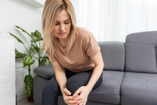 Jovem mulher sofrendo de dor no joelho, close-up
 - Foto, Imagem