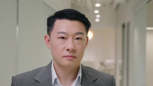 Portret poważny spokój Azji etniczny mężczyzna biznes pracodawca spokojny koreański biznesmen chiński mężczyzna japoński średnim wieku facet w biurze korytarz pewnie patrząc na aparat wykonawczy CEO w formalnym garniturze - Materiał filmowy, wideo