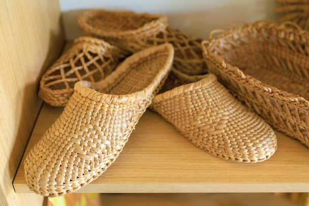 Woven straw slippers. Background with selective focus and copy space for text - Photo, Image