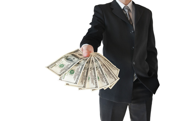 Man in zwart pak biedt geld geïsoleerd op blauwe achtergrond - Foto, afbeelding