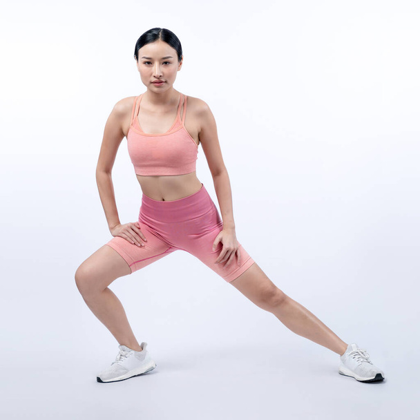 Nuori houkutteleva aasialainen nainen urheiluvaatteet venyttely ennen kunto käyttää rutiinia. Terve kehon hoito harjoitus urheilullinen nainen lämpenee studio ampui eristetty tausta. Voimakas - Valokuva, kuva