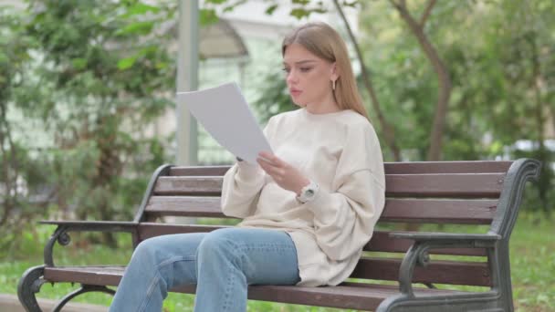 Случайная молодая женщина с потерей читает контракт на открытом воздухе - Кадры, видео