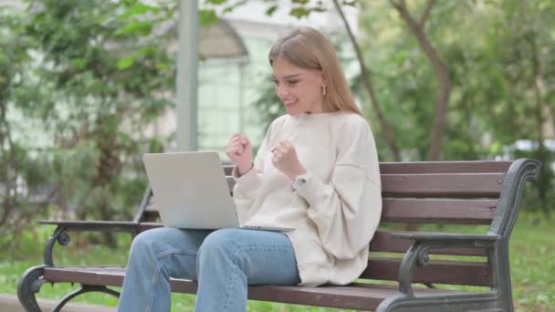 Emocionado mujer joven casual celebrando el éxito en el ordenador portátil al aire libre - Imágenes, Vídeo
