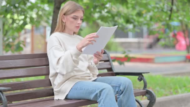 Mujer joven con pérdida de contrato de lectura al aire libre - Imágenes, Vídeo