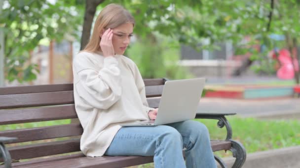 Mujer joven con dolor de cabeza Trabajando en el ordenador portátil al aire libre - Imágenes, Vídeo