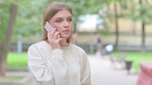 Kiireinen nainen puhuu puhelimessa ulkona - Materiaali, video