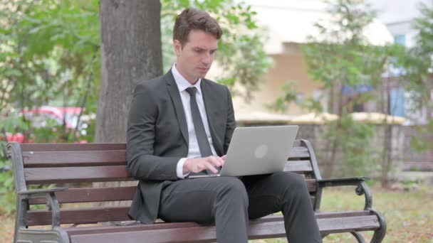 Jovem empresário animado comemorando o sucesso no laptop ao ar livre - Filmagem, Vídeo