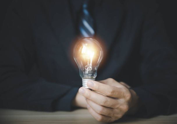 businessman holding a light bulb Digital technology. imagine an idea Creative and innovative. brain to brainstorm ideas in business. Strategies for development, growth, and success - Photo, Image