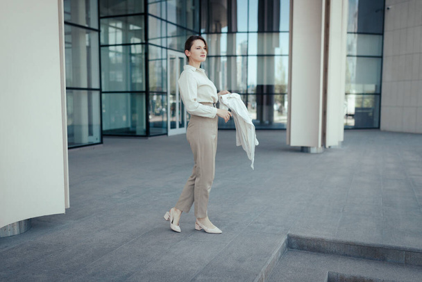 Roztomilý kavkazský žena jde do práce v kancelářském centru, Klidný béžový módní styl. - Fotografie, Obrázek