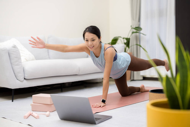 Femme asiatique faire du yoga à la maison avec son ordinateur portable - Photo, image